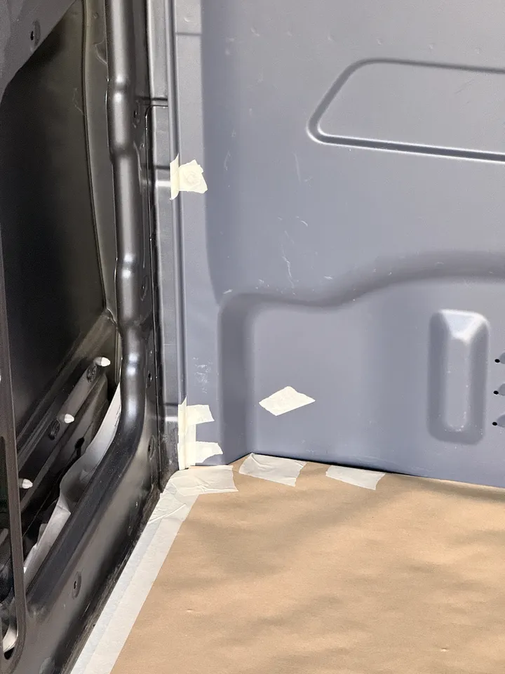 Tape along the corner where the front panel meets the wall and the floor.